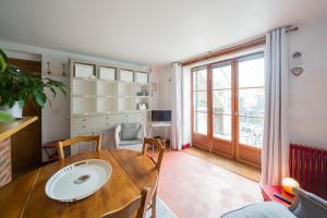 a kitchen and dining room with a table and a window at Le charmant in Bussy-Saint-Georges