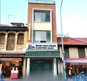 a building with a sign for a shop on a street at Beary Best! Hostel Kampong Glam in Singapore