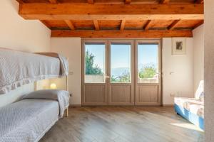 - une chambre avec 2 lits et une grande porte dans l'établissement Agriturismo La Vecchia Scuola, à Villa Collemandina