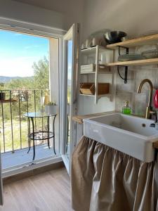 a kitchen with a sink and a large window at El Mirador de Benialfaqui, apartamento Els Olivers 