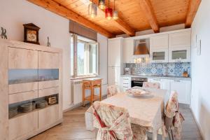 - une cuisine avec une table et des chaises dans la chambre dans l'établissement Agriturismo La Vecchia Scuola, à Villa Collemandina