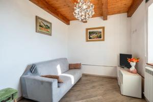 a living room with a couch and a chandelier at Agriturismo La Vecchia Scuola in Villa Collemandina