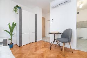 ein Wohnzimmer mit einem Tisch und einem Stuhl in der Unterkunft Apartament Dworcowa 24 in Gliwice