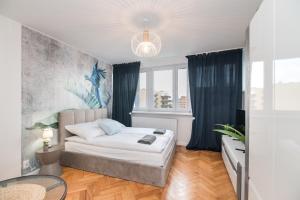 ein Schlafzimmer mit einem Bett und einem Tisch darin in der Unterkunft Apartament Dworcowa 24 in Gliwice