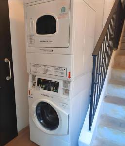 a washer and dryer in a room with a staircase at Beary Best! Hostel Kampong Glam in Singapore