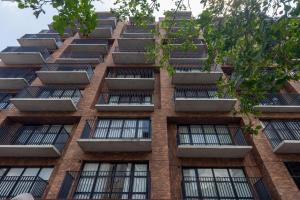 a tall brick building with lots of windows at Housi Boutique Faria Lima By Belong in Sao Paulo