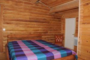 a bedroom with a bed and a wooden wall at chez jojo in Vieux-Mareuil