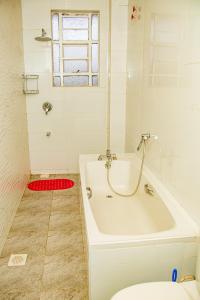 a white bath tub in a bathroom with a toilet at Kathy's Two Bedrooms in Nairobi