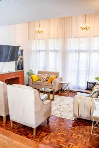 a living room with couches and a flat screen tv at Kathy's Two Bedrooms in Nairobi