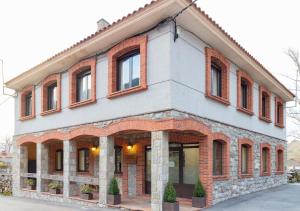 un gran edificio de ladrillo con ventanas. en Hotel Rural Rio Viejo, en Cubillas de Arbas