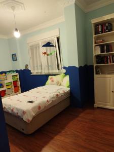 1 dormitorio con cama, ventana y estante para libros en ADEM'S SUIT 1 en Alanya