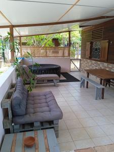 eine Terrasse mit einem Sofa und einem Tisch in der Unterkunft MO TI KOTÉ in Cayenne