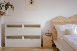 a bedroom with a white dresser next to a bed at Prostorný byt u centra Zlína s atmosférou venkova in Zlín