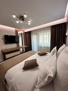 a bedroom with a large white bed with pillows at MONARC Boutique ApartHotel - SELF CHECK-IN in Iaşi