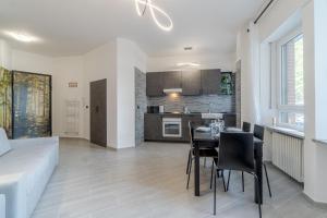 Il comprend une cuisine et un salon avec une table et des chaises. dans l'établissement Welcome to Turin! Apartment Regina Margherita, à Turin
