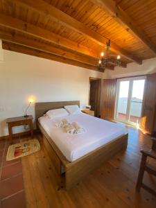 um quarto com uma grande cama branca em um quarto em Casal Serrano Charme e Tranquilidade em Reguengo Grande
