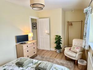 a bedroom with a bed and a chair and a television at Pass the Keys Pembroke Dock Hidden Gem in Pembroke Dock