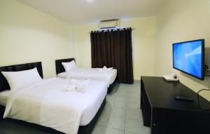 Habitación de hotel con 2 camas y TV de pantalla plana. en Paripas Express Patong, en Patong Beach