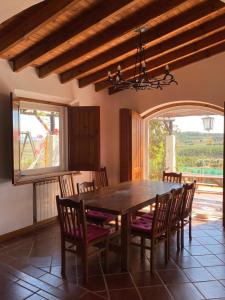 uma sala de jantar com mesa e cadeiras de madeira em Casal Serrano Charme e Tranquilidade em Reguengo Grande