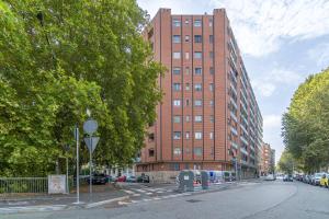 une rue urbaine vide avec un grand bâtiment en briques dans l'établissement Welcome to Turin! Apartment Regina Margherita, à Turin