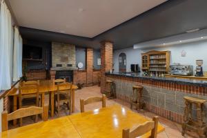 a restaurant with wooden tables and chairs and a bar at Hotel Rural Rio Viejo in Cubillas de Arbas