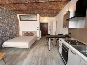 a small room with a bed and a kitchen at Nel cuore del centro storico in Cuneo