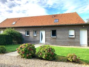 a house with a red roof and some flowers at CÔTE MER in Quiberville