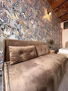 a bed in a bedroom with a floral wall at Nel cuore del centro storico in Cuneo