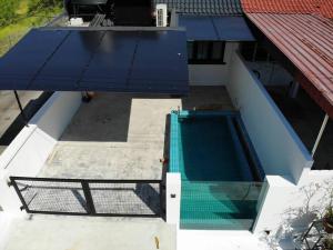 an overhead view of a swimming pool with a blue awning at Zen Retreat Glass Pool Villa in Kamunting