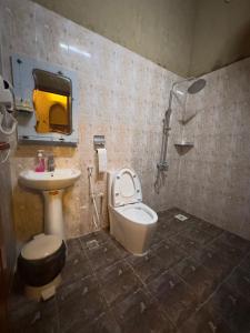 a bathroom with a sink and a toilet and a shower at AL Hamra Heritage Inn in Al Ḩamrāʼ