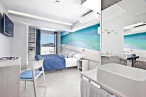 Schlafzimmer mit einem Bett, einem Schreibtisch und einem Waschbecken in der Unterkunft Ryans La Marina in Ibiza-Stadt
