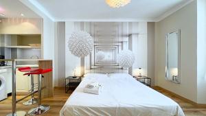 a bedroom with a large white bed with chandeliers at Hotel Le Florian in Cannes