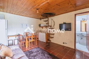 una sala de estar con una escalera de caracol y una mesa en Casa com linda vista em Campos do Jordão, en Campos do Jordão