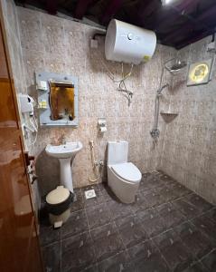 y baño con lavabo, aseo y ducha. en AL Hamra Heritage Inn, en Al Ḩamrāʼ