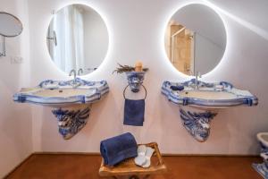 - deux lavabos dans une salle de bains pourvue de miroirs sur le mur dans l'établissement Domaine de la Cascade Parfumée, à Grasse