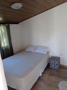 een bed in een slaapkamer met een houten plafond bij sítio recanto verde do sol in Guarapari