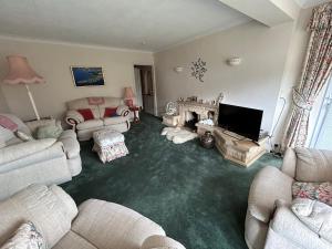a living room with couches and a flat screen tv at Curlews in Feock