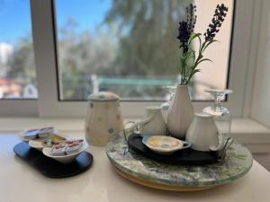 einen Tisch mit einer Glasplatte mit Vasen und einer Vase mit Blumen in der Unterkunft Wisteria in Nafpaktos