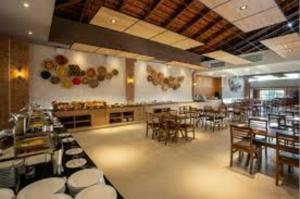 un ristorante con tavoli e sedie in una stanza di Ondas Praia Resort - MC a Porto Seguro