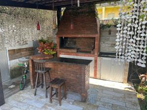 eine Außenküche mit einem Steinofen und Hockern in der Unterkunft Casa Praia de Gaibu in Cabo de Santo Agostinho