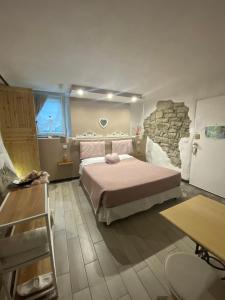 1 dormitorio con 1 cama grande y pared de piedra en B&B La casa dei cuori, en Millesimo