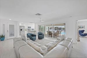ein weißes Wohnzimmer mit einem großen Sofa und einer Küche in der Unterkunft 1111 Edington Place in Marco Island