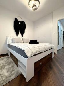 1 dormitorio con 1 cama grande con plumas negras en la pared en Stylowa Miła, en Rzeszów