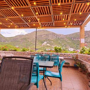 a patio with tables and chairs and mountains in the background at Hotel Maggic Home Panor&aacute;mica in Guanajuato