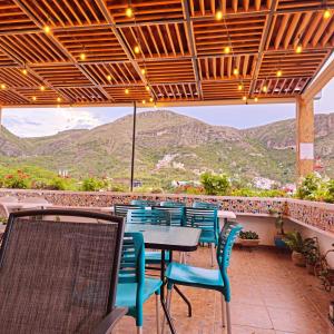 a patio with tables and chairs and mountains in the background at Hotel Maggic Home Panorámica in Guanajuato