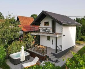 a small white house with a hot tub in front of it at Kuca za odmor Villavera in Donja Lomnica