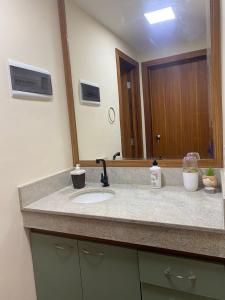 a bathroom counter with a sink and a mirror at Apt B215 Quartier - Aldeia das Águas in Barra do Piraí