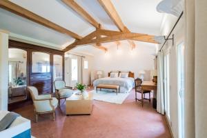 une chambre avec un lit, une table et des chaises dans l'établissement Domaine de la Cascade Parfumée, à Grasse