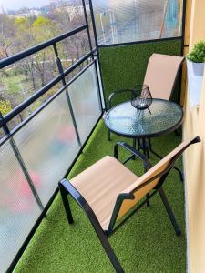 einen Balkon mit einem Glastisch und Stühlen sowie einem Tisch und Stühlen in der Unterkunft Fresh smartly designed Studio Flat & sunny balcony in Budapest