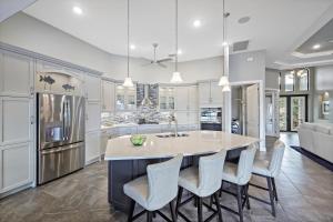 a kitchen with a large island with chairs around it at Waterfront home with W exposure, pool and spa in Marco Island